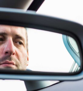 man looking in rearview mirror