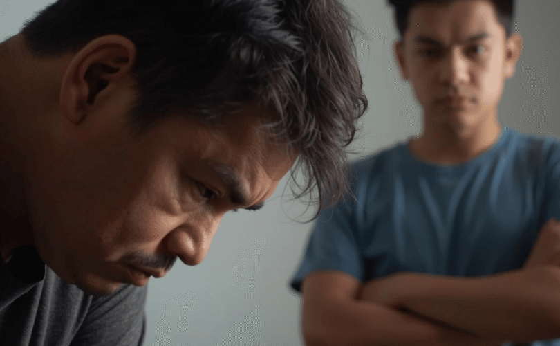 parent looking discouraged as child displays challenging behaviours